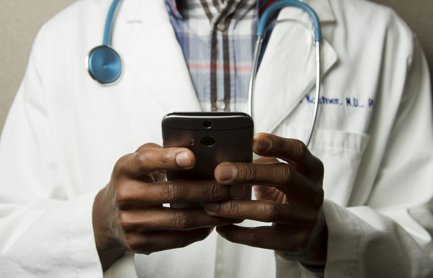 A clinician using a smartphone in a healthcare setting